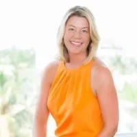 A woman in an orange dress smiling for the camera.